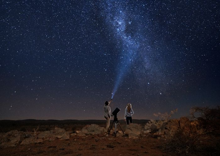 Couple star gazing beneath the Milky Way at Outback Astronomy